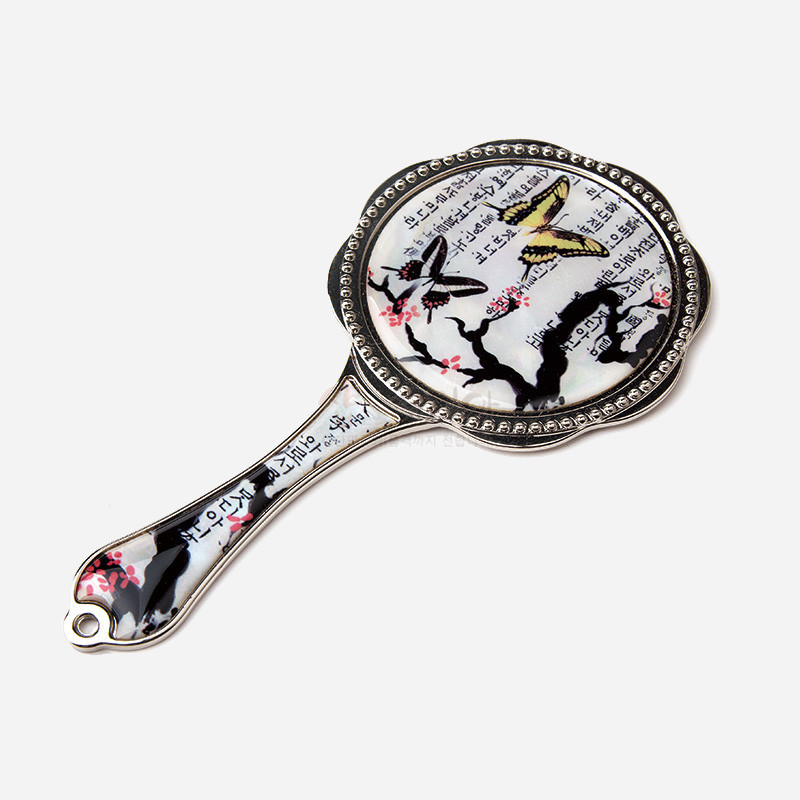 금속 손잡이 거울에 흰 바탕의 옻칠 면과 매화나비, 한글 서체 문양이 더해진 디자인.