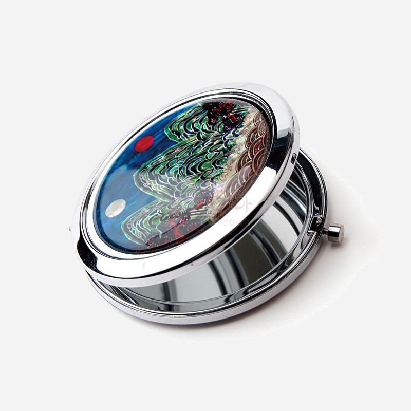 금속 테두리에 일월오봉도 자개 상감이 장식된 원형 접이식 손거울.