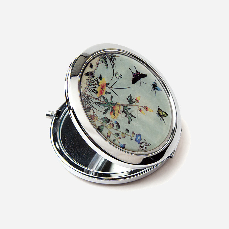 은색 금속 테두리에 꽃과 나비, 곤충 초충도 문양이 그려진 원형 자개 장식 손거울.