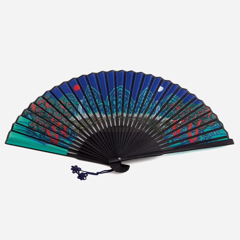 짙은 남색과 녹색 배경에 일월오봉도 민화 문양을 인쇄한 천 부채, 검은 살대와 청색 매듭 장식이 돋보이는 디자인.
