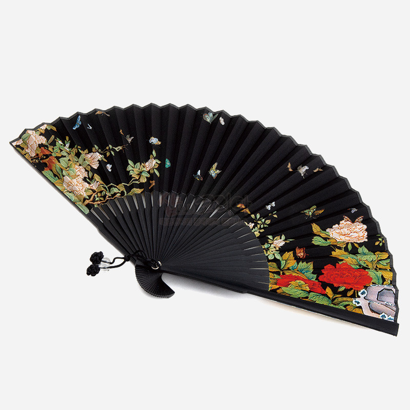 검은 바탕에 다채로운 모란과 나비 민화 문양을 채색한 전통 접선, 매듭 장식이 달린 디자인.