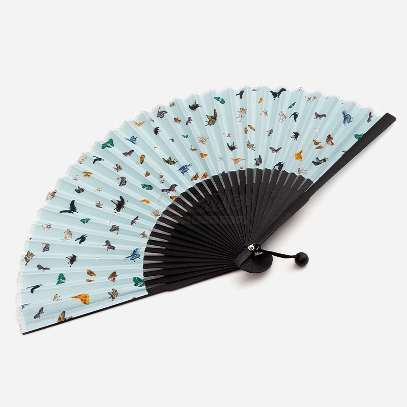 연한 하늘색 종이 위에 화조와 나비 민화 문양을 담고 검은색 대나무살과 매듭 장식이 어우러진 접선형 전통 부채.