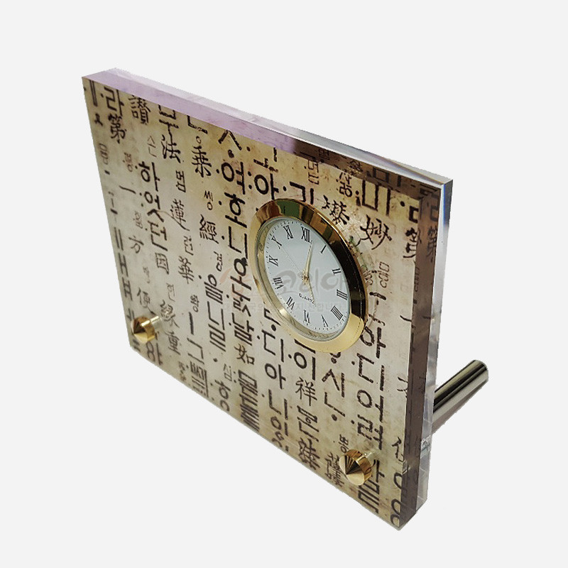 한지 질감 배경 위에 훈민정음 서체 문양과 금속 테두리 시계를 조합한 직사각 탁상시계. 한지 질감 배경 위에 훈민정음 서체 문양과 금속 테두리 시계를 조합한 직사각 탁상시계.