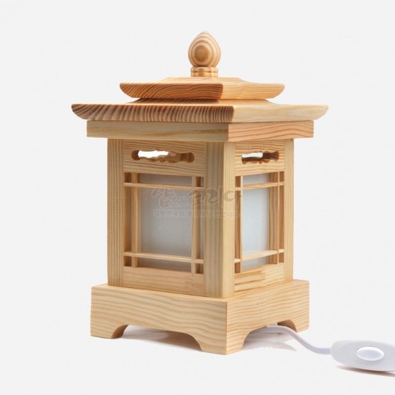 연한 원목으로 짠 사각 구조에 한지 창호 문양을 더한 전통 전등, 상부 곡선 지붕 장식이 특징인 조명. 연한 원목으로 짠 사각 구조에 한지 창호 문양을 더한 전통 전등, 상부 곡선 지붕 장식이 특징인 조명.