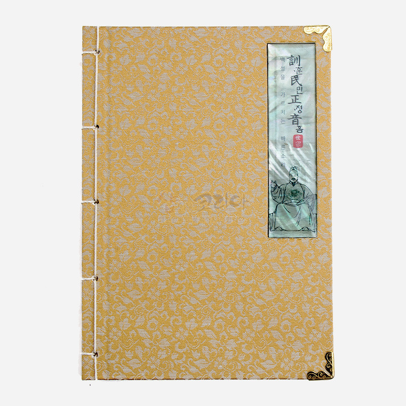 황금색 비단에 꽃무늬가 놓인 표지와 세종대왕 초상·훈민정음 글귀 자개 장식, 전통 도서식 실 제본이 특징인 노트.