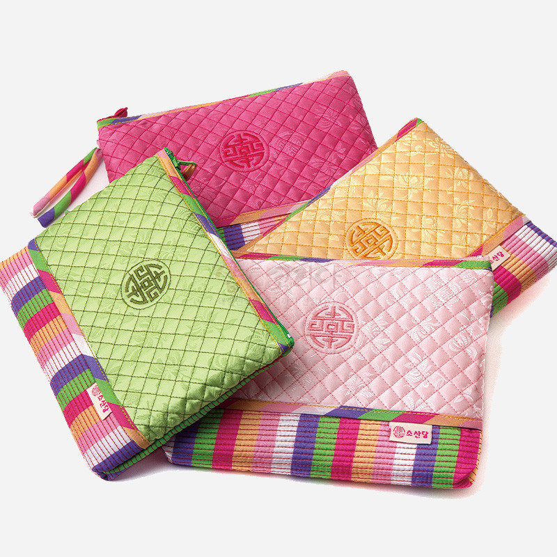 분홍색 비단 누비 기법에 길상문 자수와 색동 줄무늬 배색이 돋보이는 전통 파우치. 분홍색 비단 누비 기법에 길상문 자수와 색동 줄무늬 배색이 돋보이는 전통 파우치.