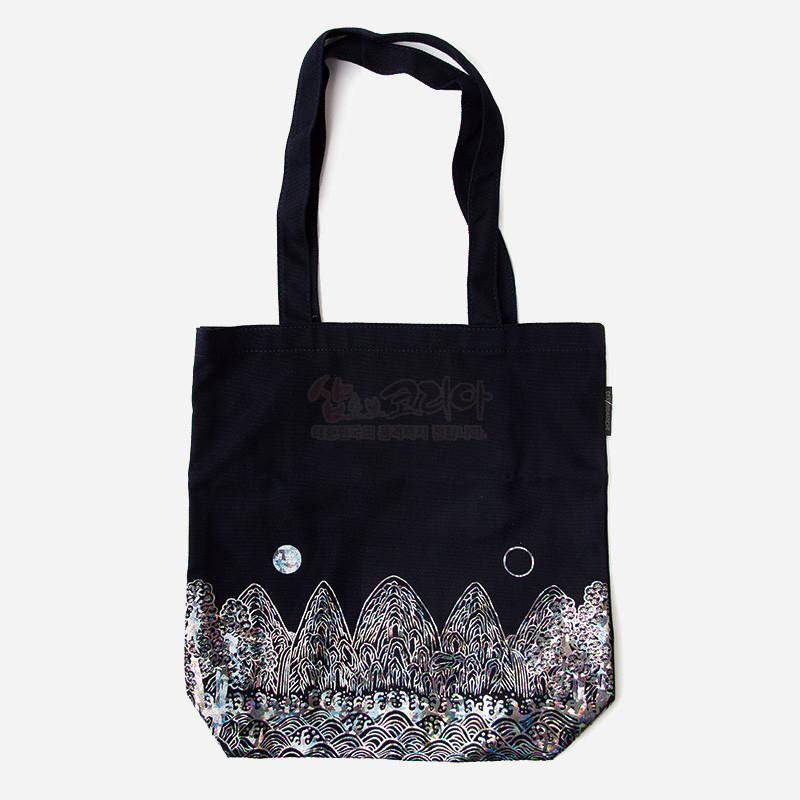 검정 천 소재 위에 자개 포인트로 표현된 일월오봉도 산수 문양과 파도무늬가 특징인 에코백.