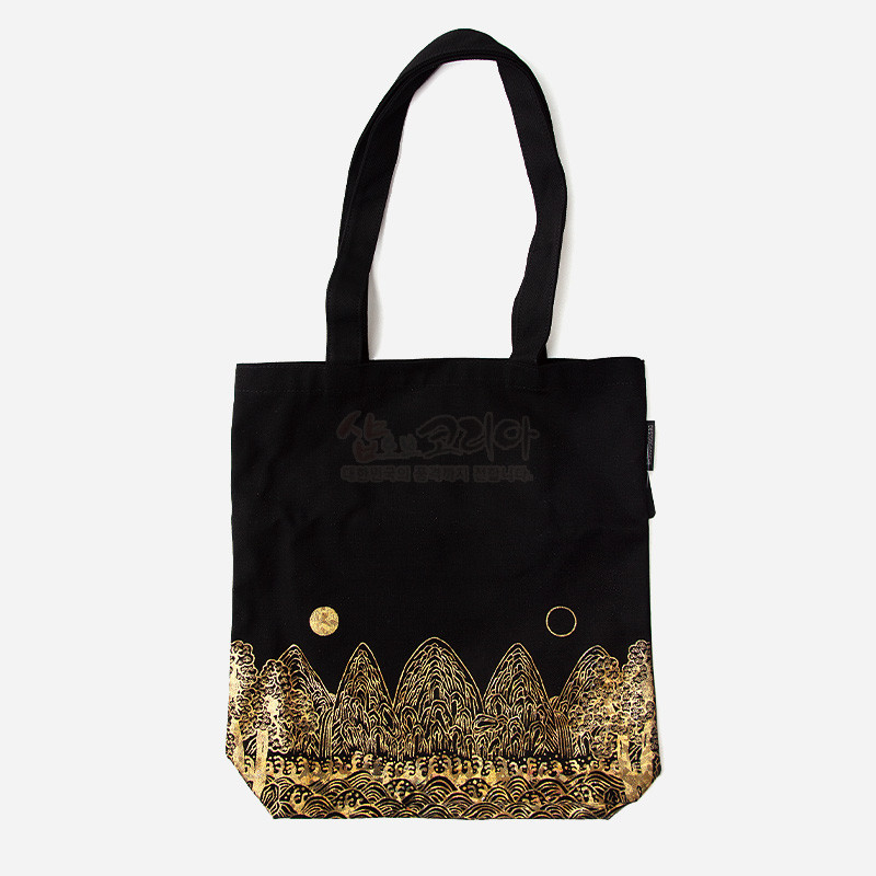 검은 천 소재에 금색 일월오봉도 산수와 태양·달 문양이 실크스크린으로 표현된 에코백.