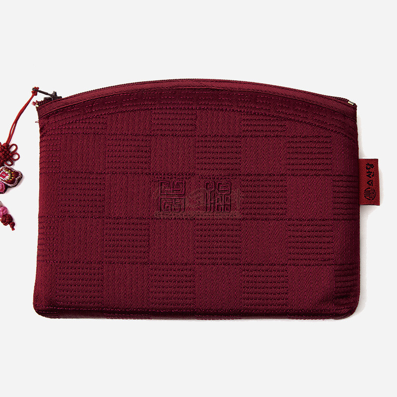 적갈색 누비 처리 원단에 격자 짜임과 전통 문양이 더해진 지퍼형 파우치.