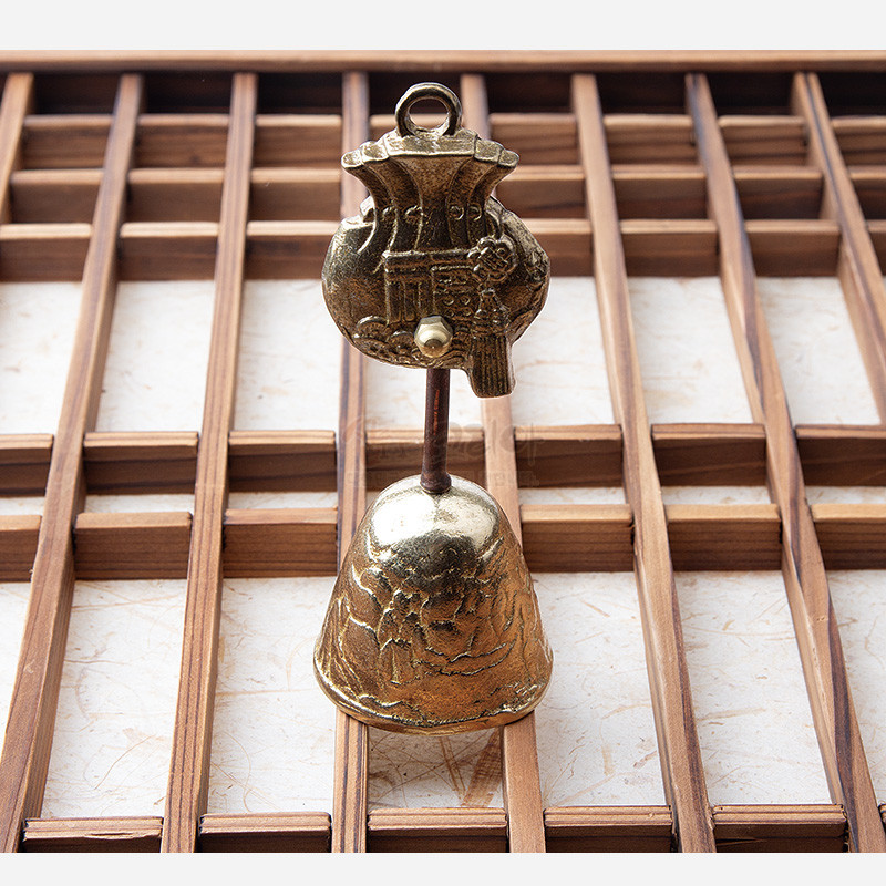 황동 재질로 제작된 종 형태 장식, 상단 복주머니와 하단 연꽃 문양 양각 장식이 특징인 소형 전통 종.