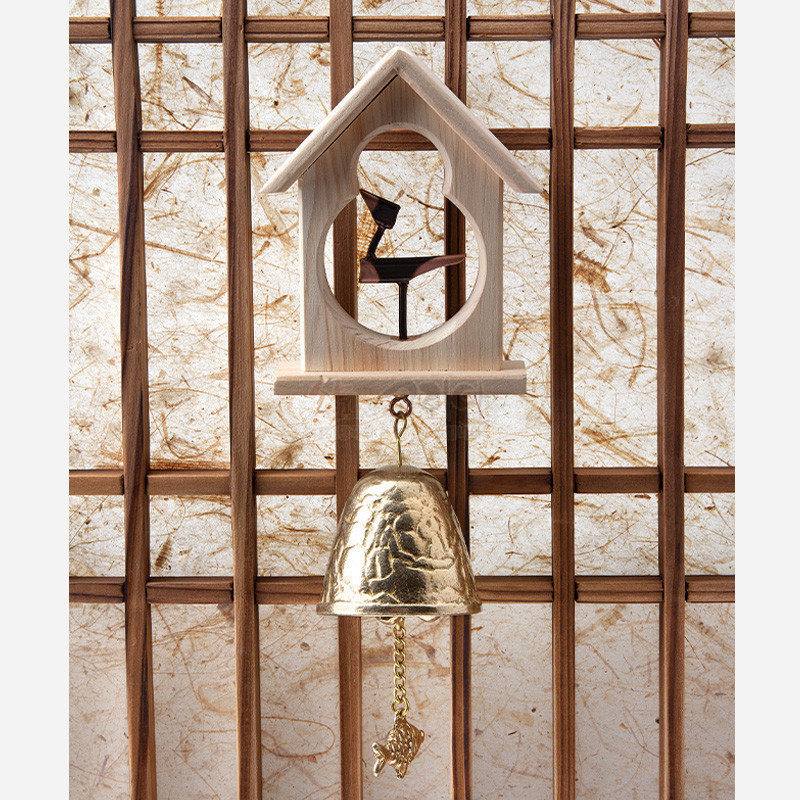 밝은 원목 틀과 검은 솟대 장식, 황동 종과 물고기 장식 추로 구성된 전통 문종.