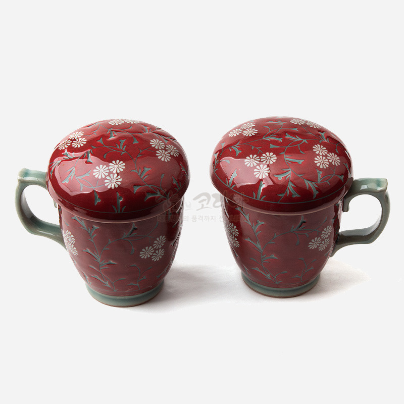 붉은 유약 바탕에 국화와 넝쿨 문양이 시문된 도자 머그와 뚜껑 세트, 연녹색 손잡이와 굽이 대비를 이루는 디자인.