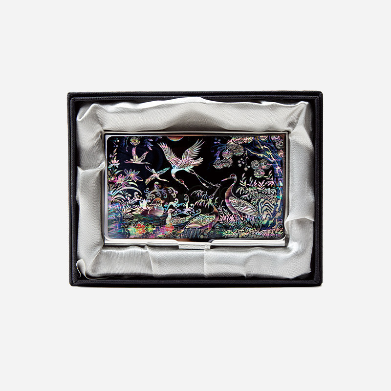 자개 상감 기법으로 흑색 바탕에 송학과 파도, 꽃과 나무 문양을 섬세하게 표현한 금속 명함집.