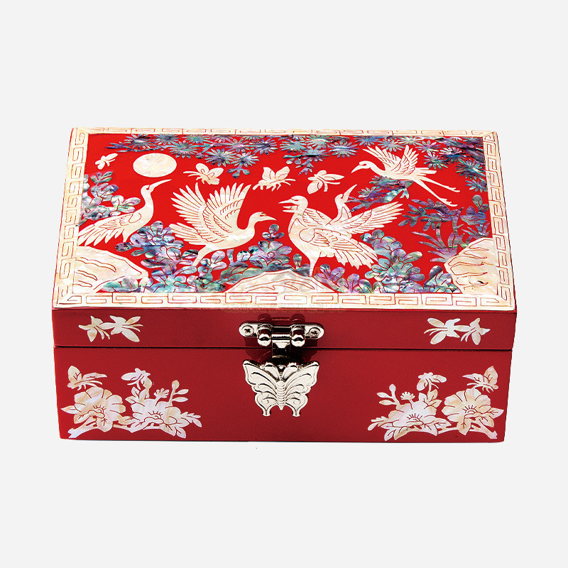 붉은 옻칠 바탕에 자개 상감으로 달과 학, 모란과 구름 문양을 섬세하게 표현한 금속 잠금장식 보석함.