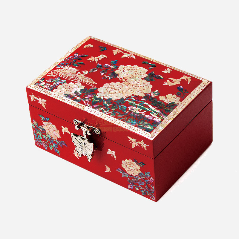 붉은 옻칠 바탕에 자개 상감 기법으로 모란과 나비 문양을 장식하고 금속 나비 장식 잠금장치를 더한 직사각 보석함.