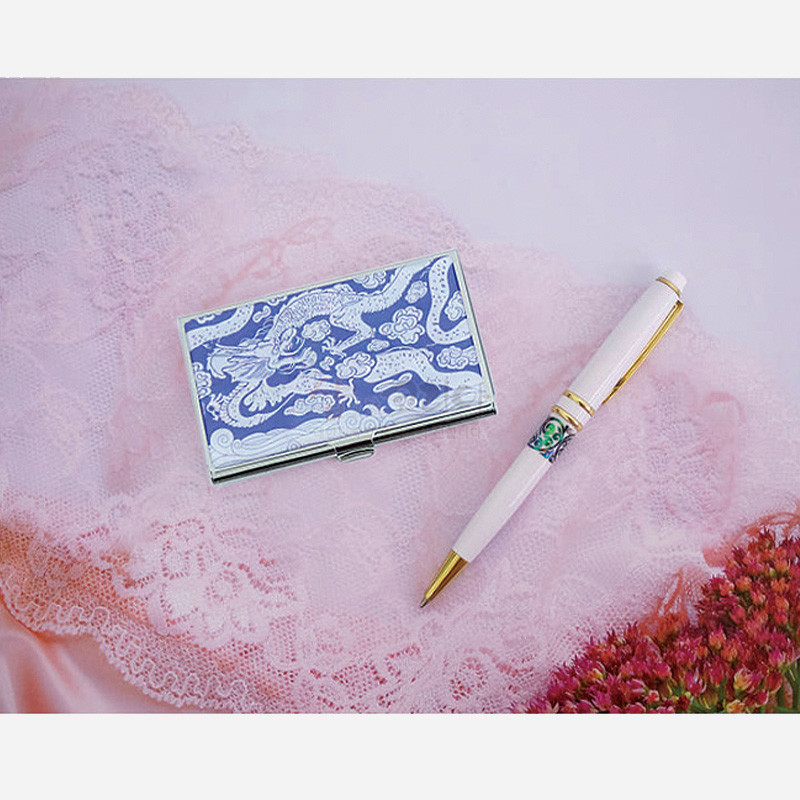 청색 구름과 용 문양이 새겨진 금속 명함케이스와 자개 장식 띠를 둘린 백색 금속 볼펜 2종 세트.