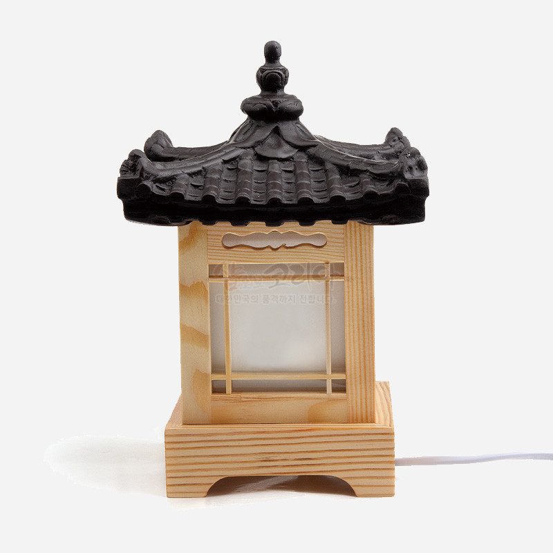 나무 재질 사각 몸체에 창살 구조와 반투명 백색 창호지를 더하고, 검은 기와 지붕 장식을 올린 전통 형태 조명.