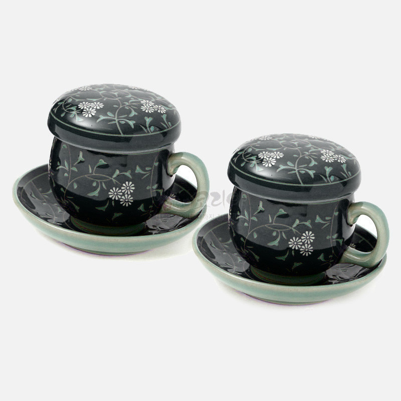 검은 바탕 도자기에 흰 국화와 연두 덩굴무늬가 둘러진 뚜껑잔과 받침 접시 세트.