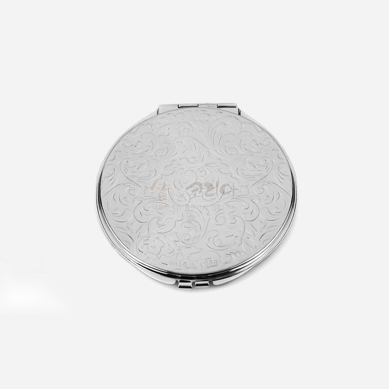 은색 금속 재질에 섬세한 스크롤 문양이 양각된 원형 자개손거울.