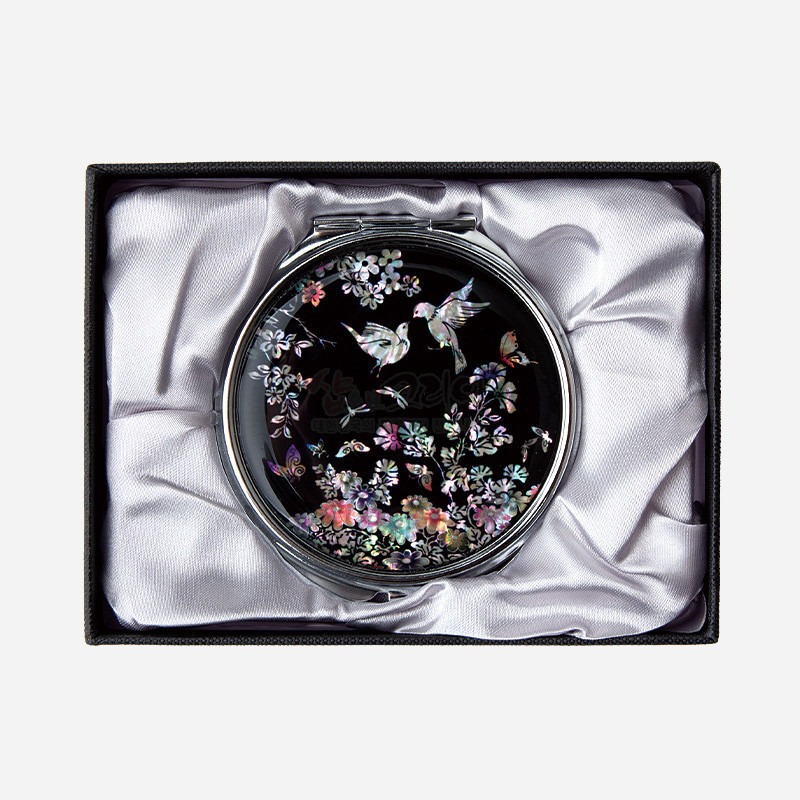 자개 상감 기법으로 새와 꽃, 나비 문양을 장식한 흑색 바탕의 원형 금속 손거울. 자개 상감 기법으로 새와 꽃, 나비 문양을 장식한 흑색 바탕의 원형 금속 손거울.