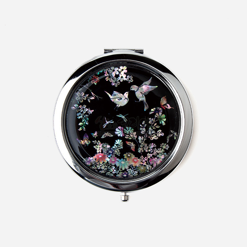 자개 상감 기법으로 화조도와 꽃, 나비 문양을 그린 검은 바탕의 원형 금속 손거울.