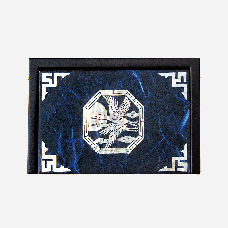 짙은 남색 바탕 위 자개로 상감된 청학과 팔각 기하학 문양, 모서리 전통 문양 장식의 나전칠기 한지 명함함. 짙은 남색 바탕 위 자개로 상감된 청학과 팔각 기하학 문양, 모서리 전통 문양 장식의 나전칠기 한지 명함함.