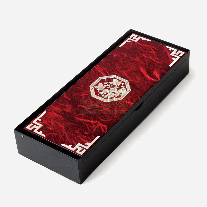 붉은 한지 위에 옻칠 마감된 직사각형 필함, 중앙 팔각 자개 매화문과 모서리 백색 전통문양 장식.