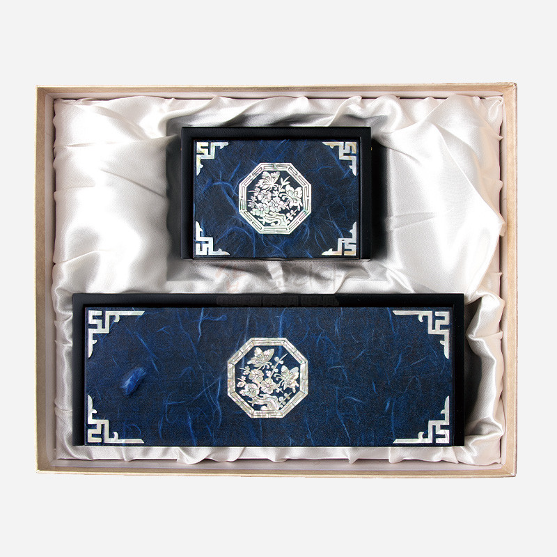 청색 한지 바탕 위 자개 상감으로 청매화와 나비 문양을 넣고 모서리에 전통 기하학 무늬를 장식한 필함·명함함 세트.