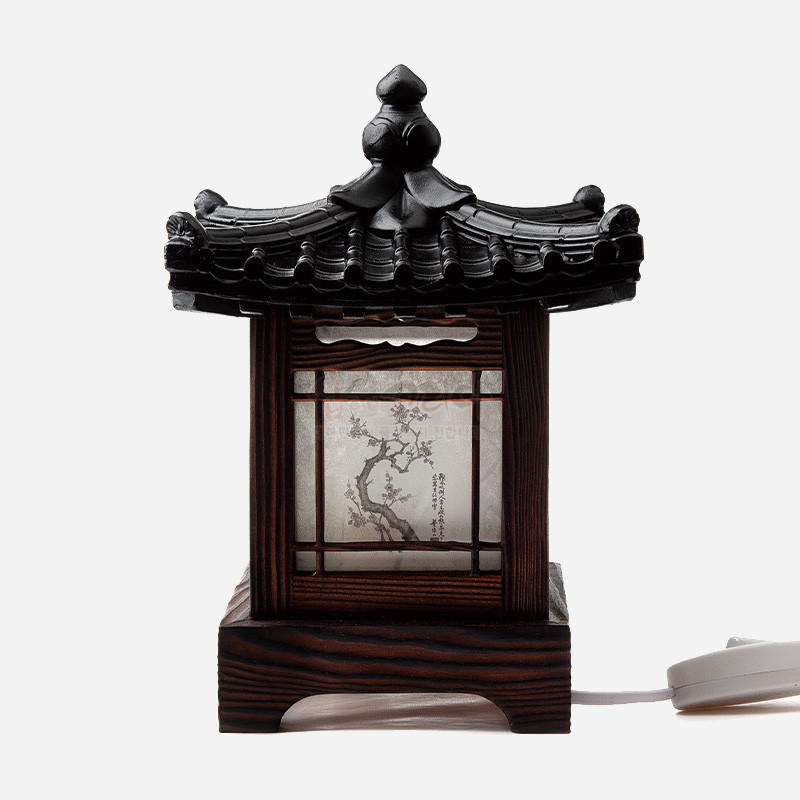 전통 기와지붕 형태의 목재 좌등, 반투명 지에 사군자 수묵화와 창살 문양이 어우러진 조명 장식.