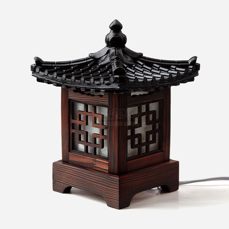 짙은 갈색 목재와 흑색 기와 지붕, 반투명 창에 완자문 격자 장식이 돋보이는 작은 좌등.