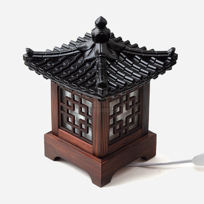 짙은 갈색 목재와 흑색 기와 지붕이 조화된 구조, 창문에 정(井)자 완자문이 장식된 전통 좌등형 조명.