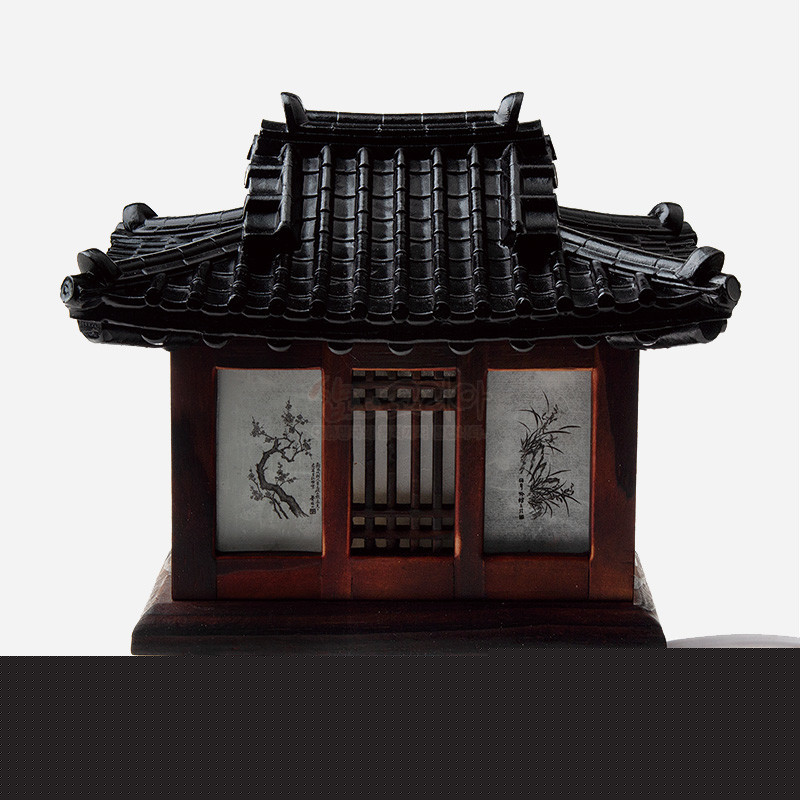 목재로 제작된 전통 기와집 형태 작은 좌등, 검은 기와 지붕과 창호 사이 수묵화 매화·대나무 문양이 특징인 조명 장식.