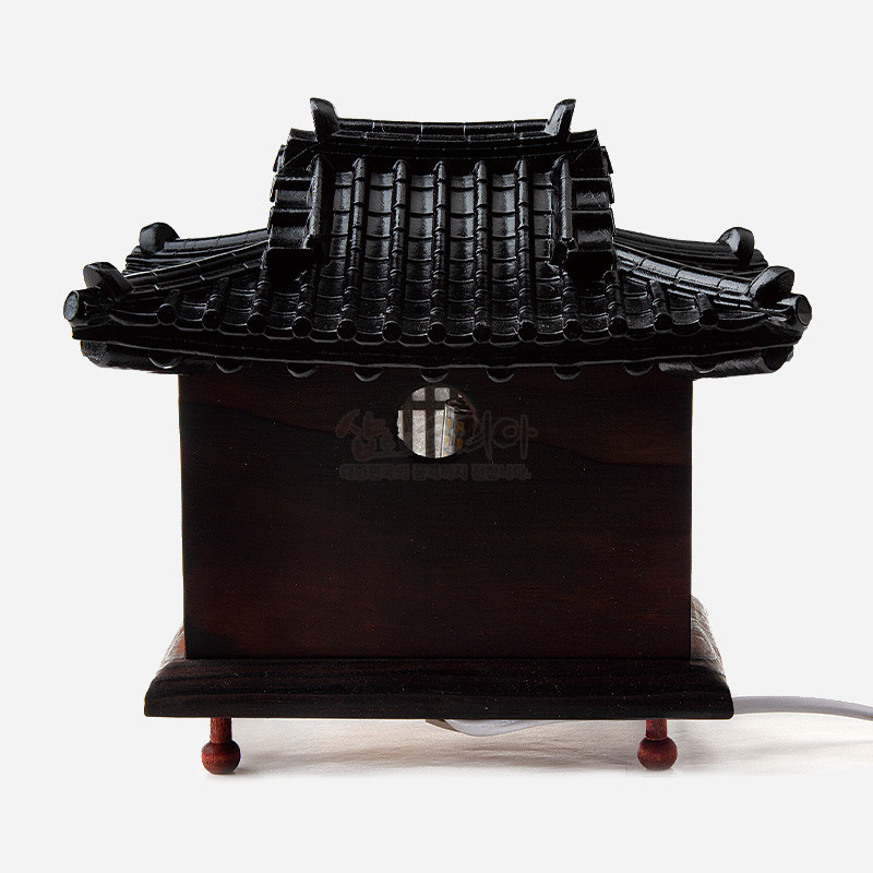 짙은 색 목재 위에 기와를 정교하게 조각한 전통 한옥 지붕 형태의 소형 좌등. 짙은 색 목재 위에 기와를 정교하게 조각한 전통 한옥 지붕 형태의 소형 좌등.