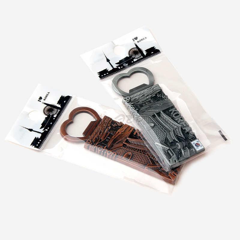 금속 소재에 입체적으로 표현된 북촌 한옥 지붕과 골목 풍경, 하트형 손잡이와 은은한 갈색·회색 톤이 특징인 병따개 겸용 메모 자석. 금속 소재에 입체적으로 표현된 북촌 한옥 지붕과 골목 풍경, 하트형 손잡이와 은은한 갈색·회색 톤이 특징인 병따개 겸용 메모 자석.