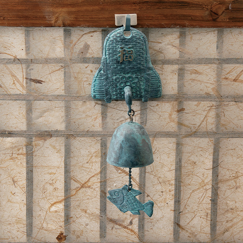 청동 재질의 문종에 복자와 기와 문양, 종 아래 물고기 장식이 달린 청녹색 풍경 장식.