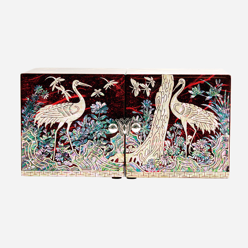 적색 옻칠 바탕에 자개 상감 기법으로 송학과 꽃, 구름문양을 섬세하게 표현한 나전칠기 쌍합.