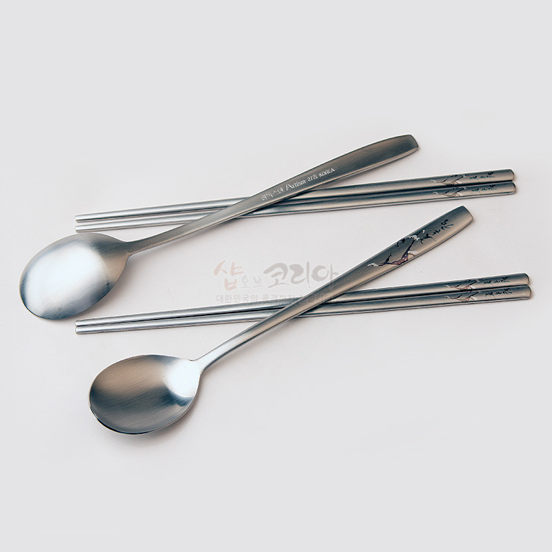 스테인리스 소재에 은은한 무광 마감과 소나무 설경 문양이 새겨진 수저 2인 세트.