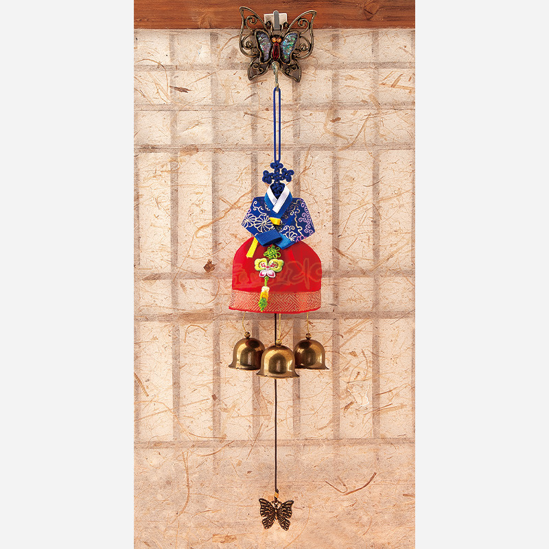 청색 저고리와 홍색 치마 비단 한복 장식, 매듭 장식과 금속 나비 고리, 종 세 개로 구성된 전통 문종.