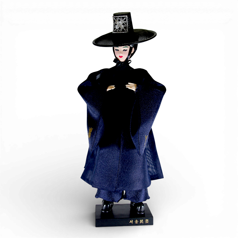 짙은 남색 비단 한복과 전통 갓을 쓴 저승사자 인형, 소매 금색 자수 문양이 포인트인 장식 인형.