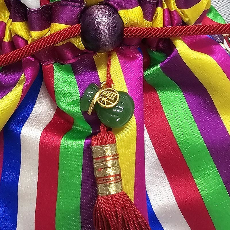 비단 소재 오방색 색동 배색에 매듭 기법을 더한 복주머니, 옥색 호리병 장식과 붉은 술이 조화된 손지갑.