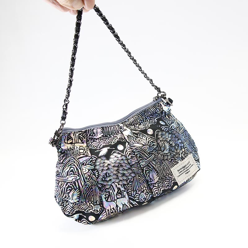 십장생 산수와 동물 문양을 자개 느낌의 홀로그램 소재로 표현한 블랙 톤 작은 핸드백.