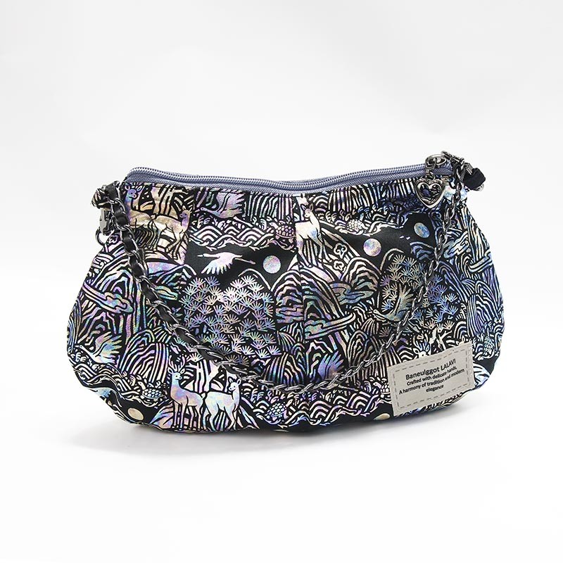 십장생 산수와 학, 사슴 문양이 인쇄된 비단 소재, 은빛 계열 색감과 금속 체인 스트랩이 어우러진 작은 핸드백.