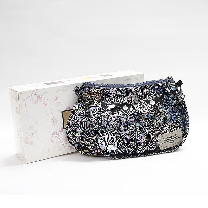 자개 느낌의 광택 실사와 직조 기법으로 표현된 십장생 문양, 검정 바탕에 오색 무늬가 돋보이는 작은 핸드백.