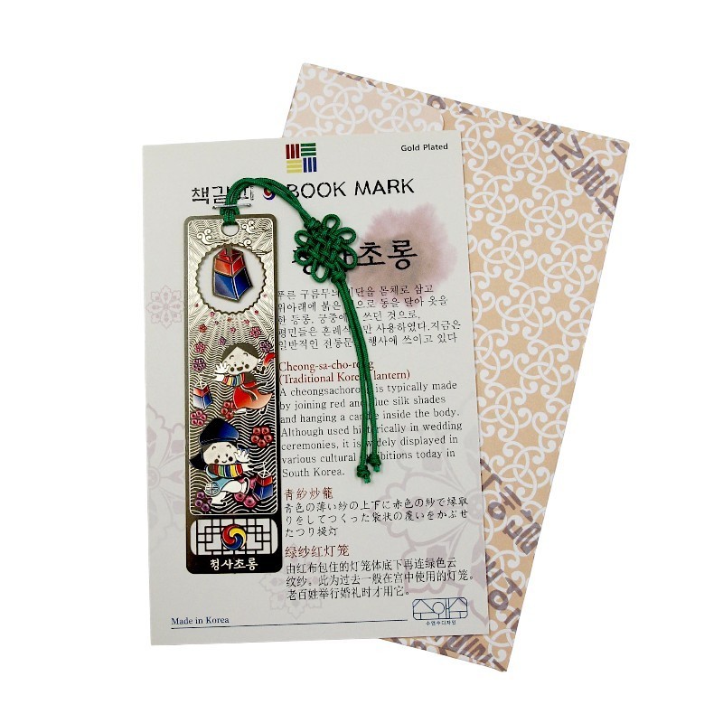 금도금 금속 재질에 청사초롱과 동자 문양을 채색한 책갈피, 초록 전통 매듭 장식이 특징인 디자인.