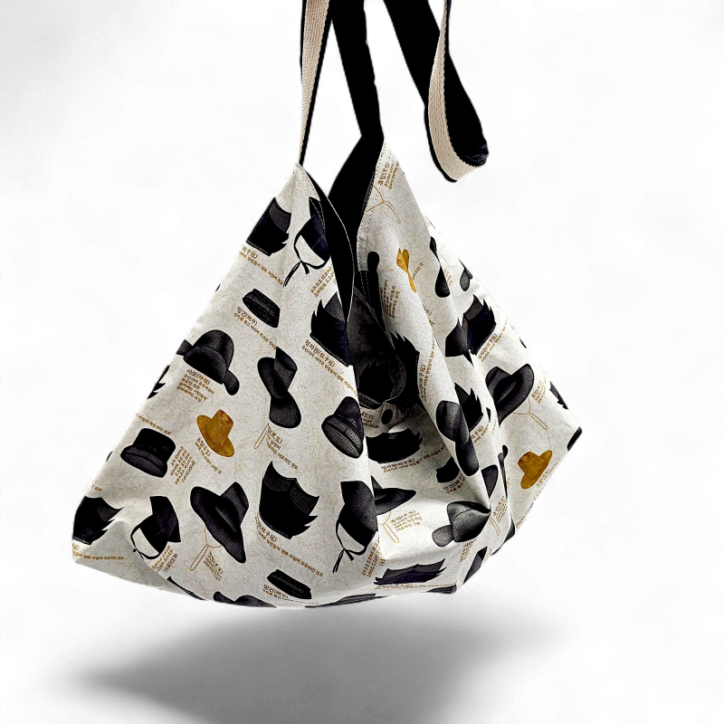 면 소재에 한국의 갓과 전통 모자 실루엣 패턴이 인쇄된 베이지색 대형 숄더가방. 면 소재에 한국의 갓과 전통 모자 실루엣 패턴이 인쇄된 베이지색 대형 숄더가방.