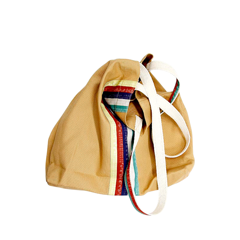 베이지 면 소재에 흰색 스트랩과 훈민정음 글자가 새겨진 오방색 스트라이프 장식이 특징인 에코백.