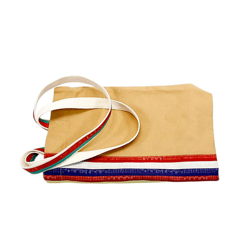 베이지색 천에 붉은색·파란색 훈민정음 문양 띠 장식과 흰색 어깨끈이 조화된 패브릭 에코백.