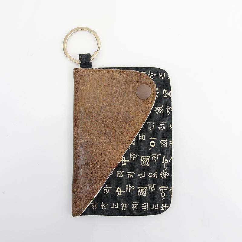 갈색 가죽과 검은 천 소재 조화, 금색 한글 서체 문양이 더해진 키링 장식 카드지갑.