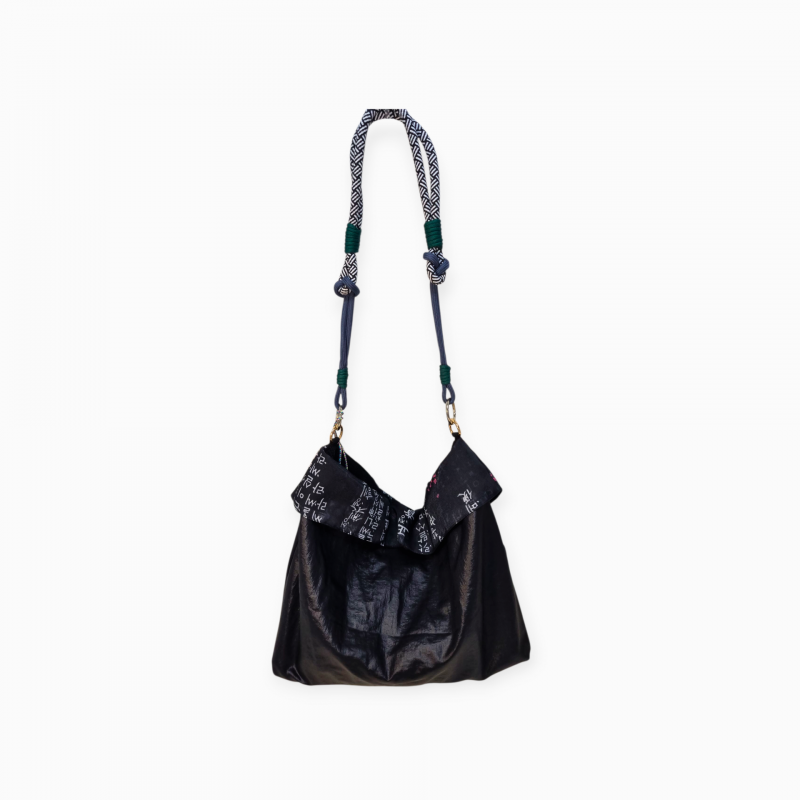 검은색 천 소재에 훈민정음 서체 패턴 장식, 배색 매듭 끈이 특징인 버킷백.