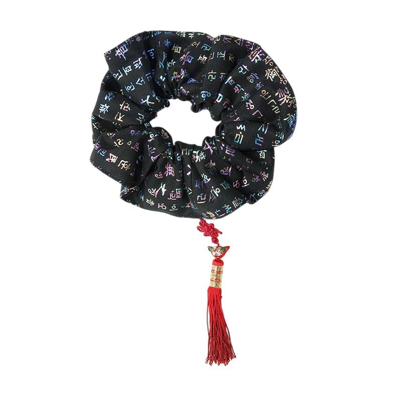 검은색 비단 위에 다채로운 훈민정음 문자 문양이 수놓인 헤어밴드와 붉은 매듭 술 장식.